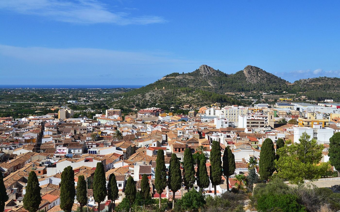 Rooftops of Pedreguer with cypress trees, hills and the Mediterranean behind, Alicante, Spain