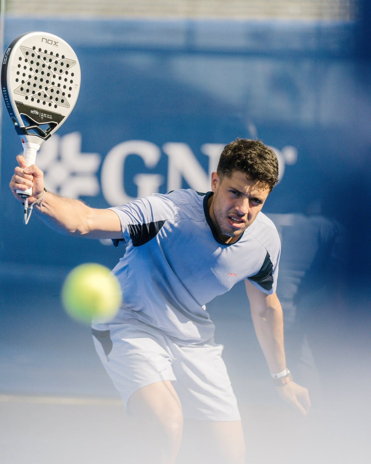 Padel player hitting a forehand at a tournament