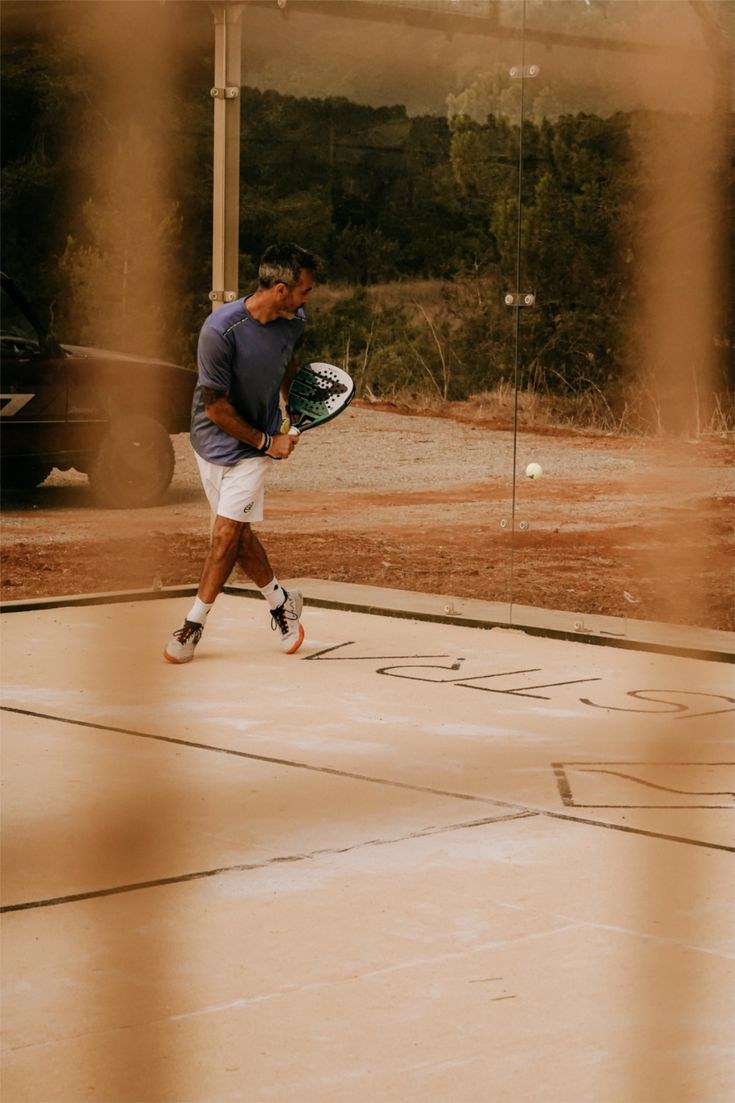 Padel player on an outdoor court in warm evening light
