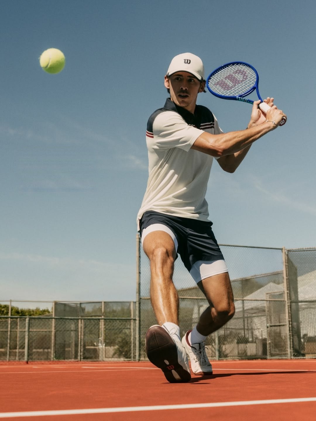 Tennis player hitting a forehand on a clay court