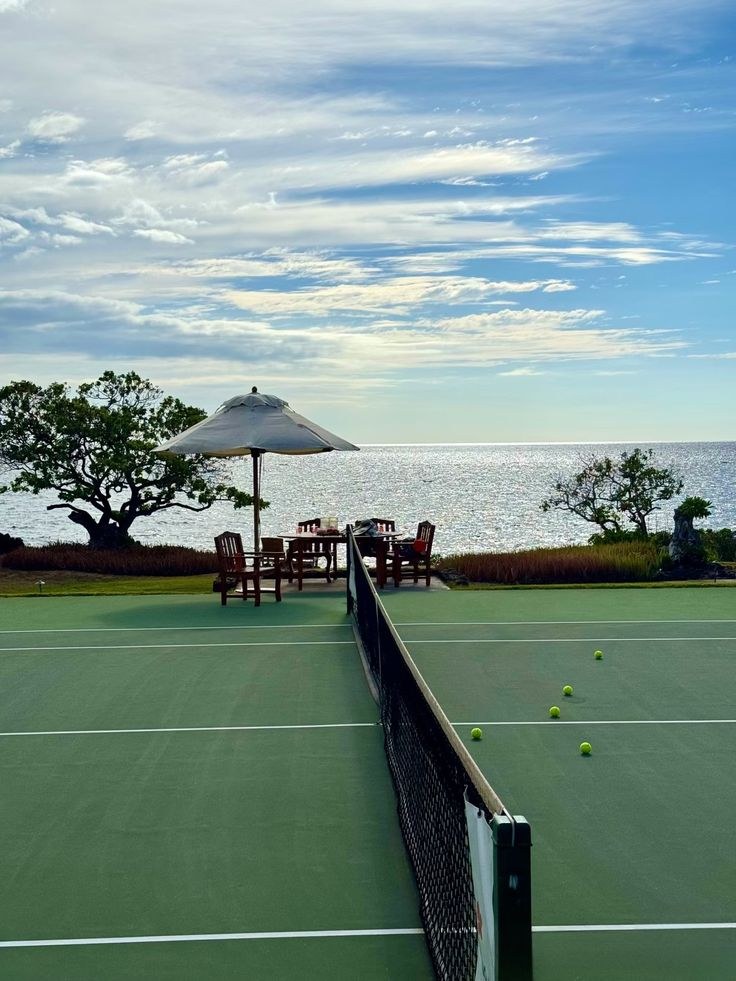 Tennis court beside the sea with balls on the baseline