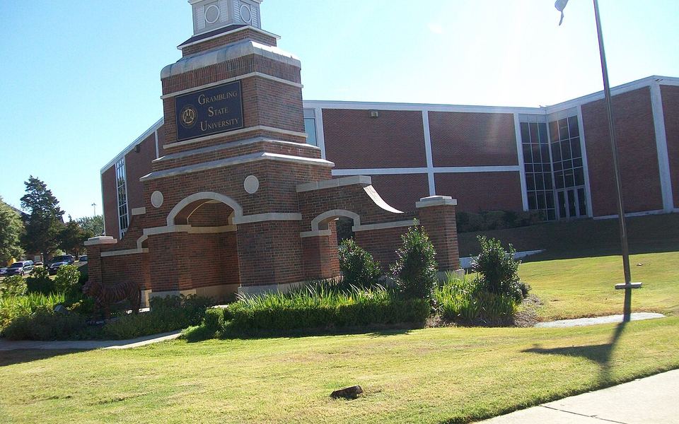 The red-brick Grambling State University entrance monument, with the university&rsquo;s name on a plaque and a tiger statue at its base, in front of a brick campus building in Grambling, Louisiana