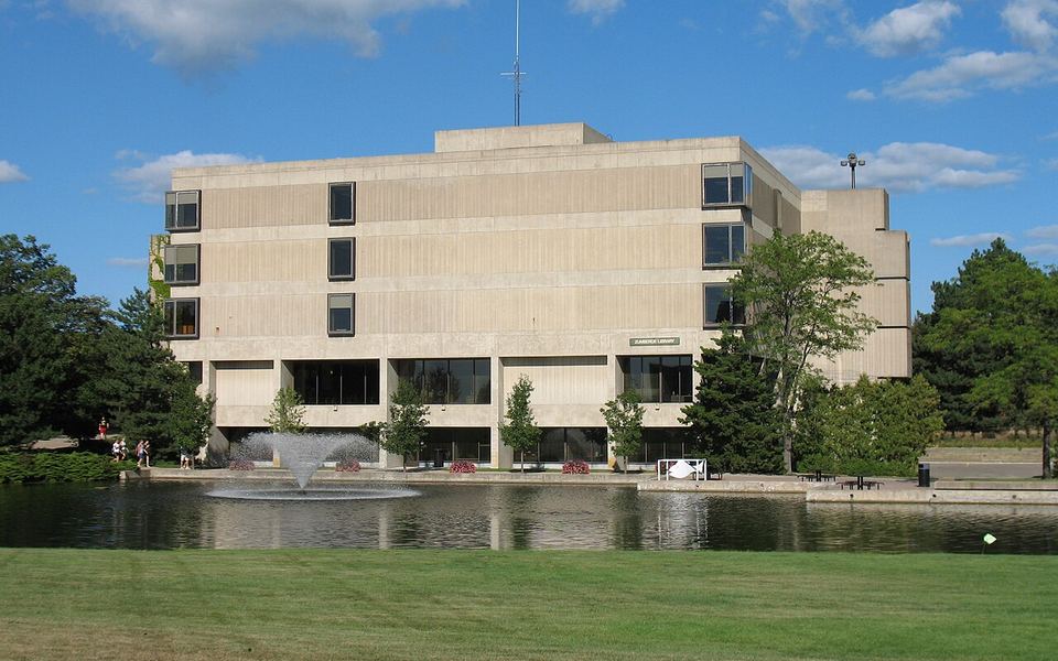 The James H. Zumberge building, Grand Valley State University&rsquo;s original library (photographed in 2006), behind a pond with a fountain and a wide lawn on the campus in Allendale, Michigan