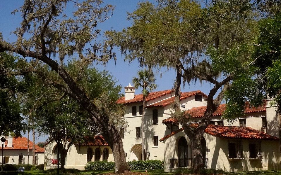 White Spanish-style buildings with red-tile roofs under live oaks and Spanish moss on the Rollins College campus in Winter Park, Florida